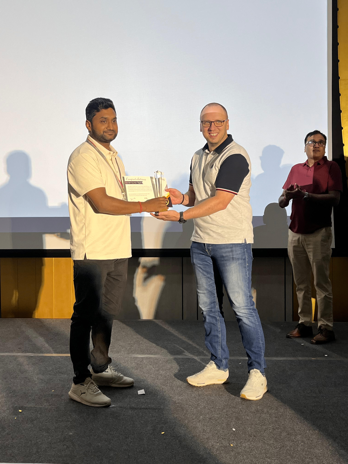 Manish Kumar Rajak receiving the Employee of the Year 2025 award on stage at Fossil Group